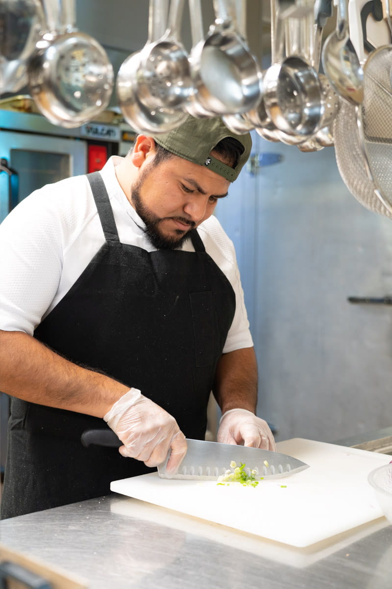 A chef chops up onions while preparing a meal