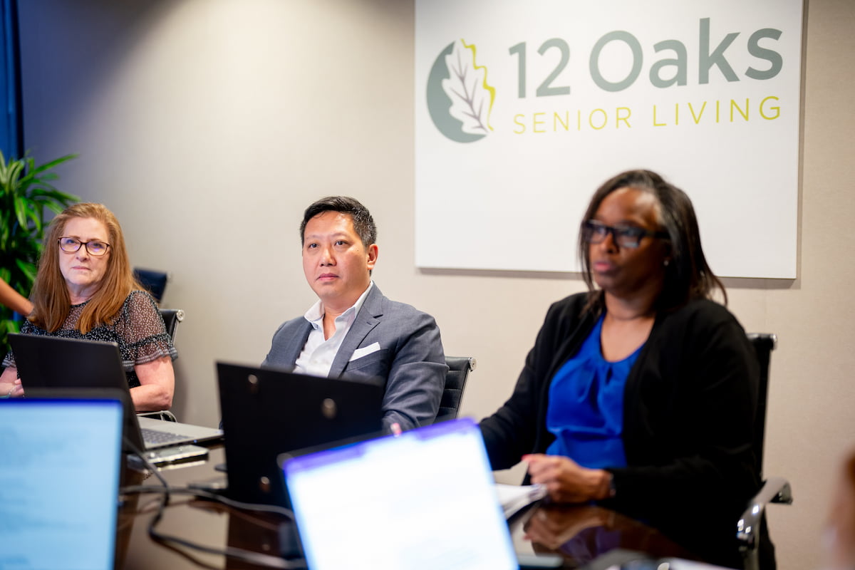 12 Oaks team members engage in discussions during a meeting