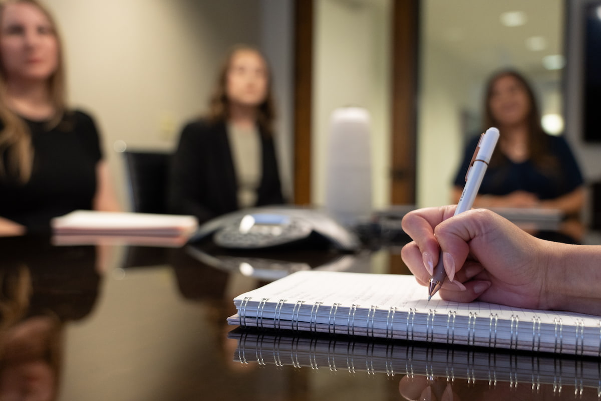 Taking notes during a team meeting at 12 Oaks Senior Living